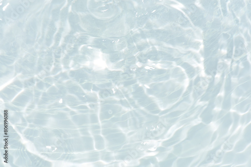 White water with ripples on the surface. Defocus blurred transparent white colored clear calm water surface texture with splashes and bubbles. Water waves with shining pattern texture background. photo