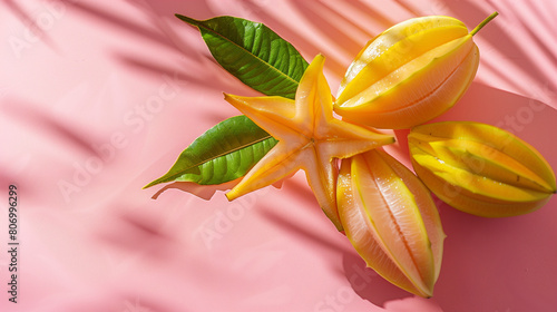 exotic tropical starfruit on plain yellow color wall with shadows and sunlight photo