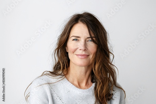 Confident Mature Woman in White Sweater Smiling on a Plain Background © atdigit
