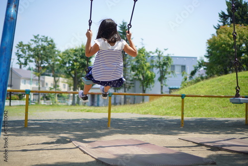 ブランコに乗って遊んでいる小学3年生の女の子