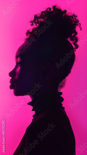 Close up Portrait of silhouette of a beautiful girl profile with neon vibrant pink color light background. Fashion style portrait of strong and self-confident young black, african-american model woman