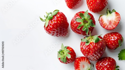  A cluster of strawberries arranged on a white backdrop, garnished with green leaves atop