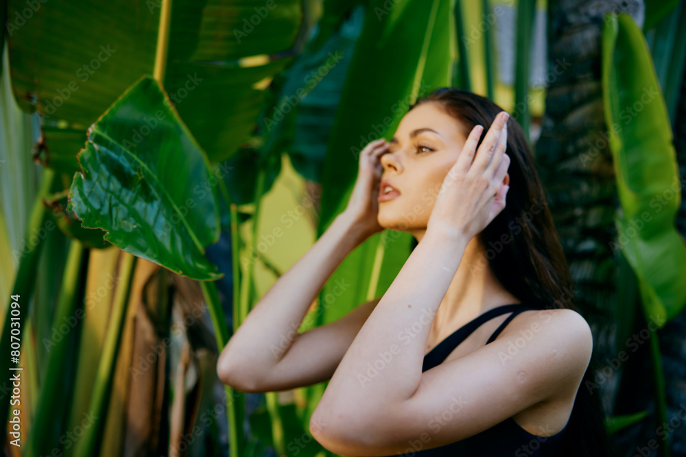 Stressed woman standing in front of green plant with hands on head in distress and frustration Stressed woman standing in front of green plant with hands on head in distress and frustration