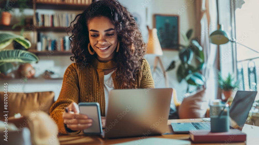A woman is sitting at a desk with a laptop and a cell phone A woman is sitting at a desk with a laptop and a cell phone