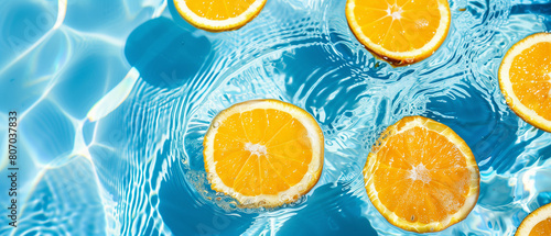 A refreshing summer backdrop showcasing orange fruit slices immersed in a pool of water. This summer-themed wallpaper offers ample room for text.