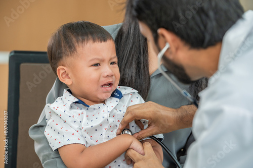 Crying toddler getting a check up from the doctor