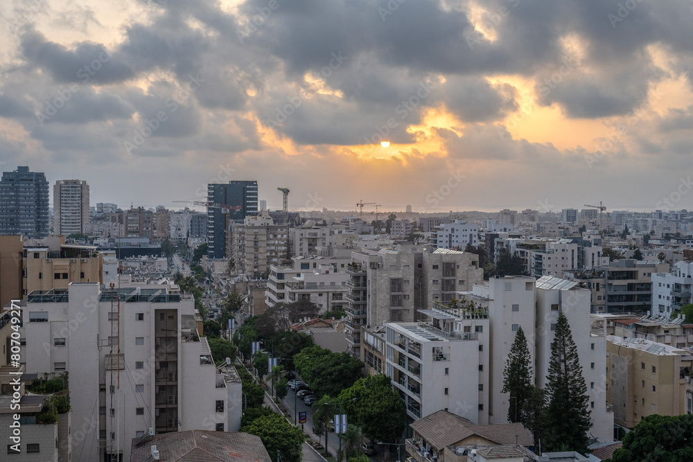 Sunset over the sea in the city of Herzliya, with buildings and construction cranes