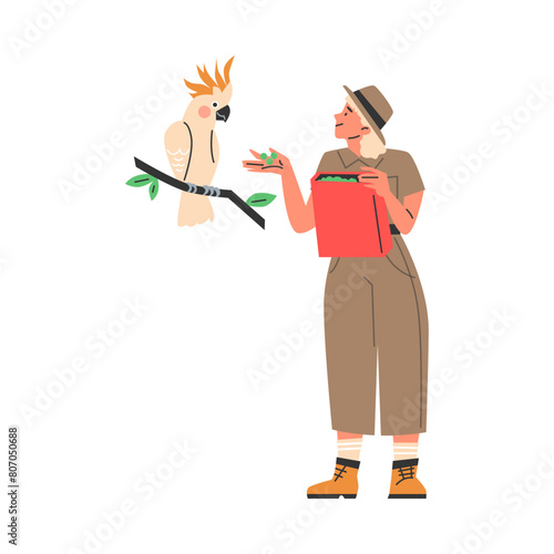 Smiling young woman zoologist feeding cute cockatoo