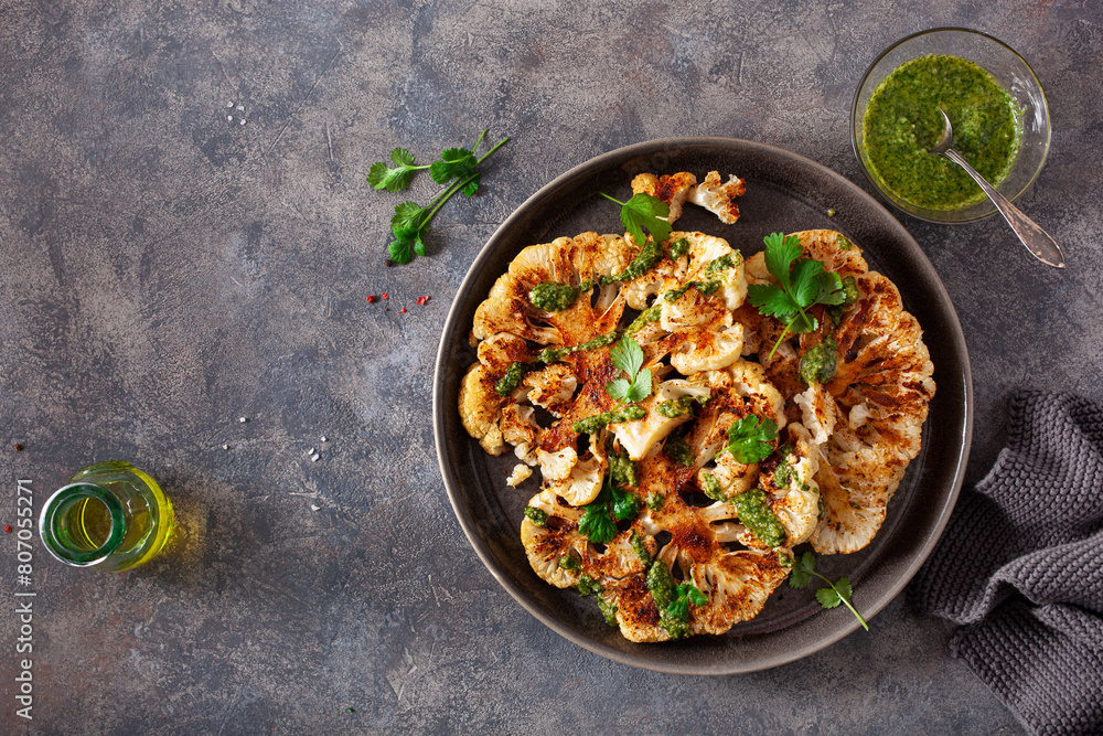 cauliflower steaks with herb sauce and spice. plant based meal
