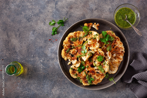 Obraz na płótnie cauliflower steaks with herb sauce and spice. plant based meal w salonie