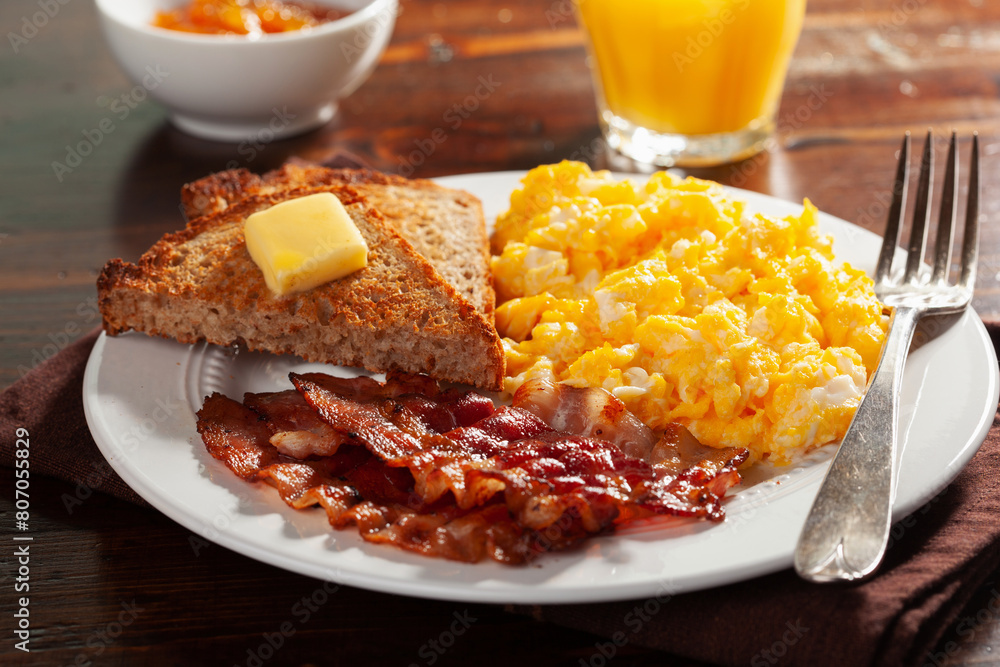 traditional scrambled egg breakfast with bacon and toast