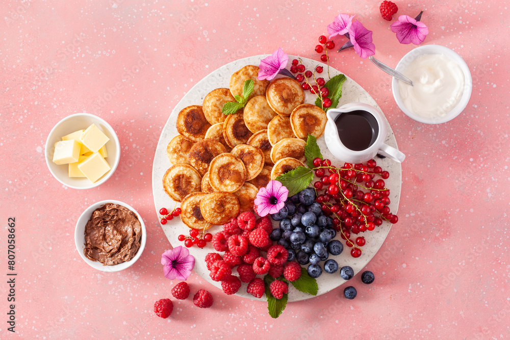 american mini pancake board with berries and maple syrup