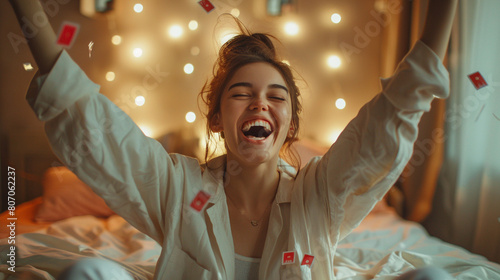 Woman in pajamas celebrating victory, ecstatic expression, lottery ticket on the bed. photo