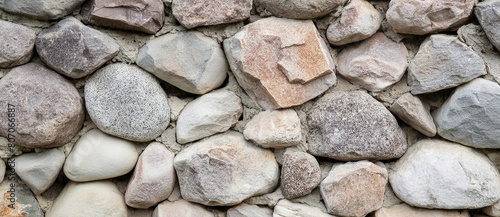 natural stone wall of round stone, front and back background blurred with bokeh effect