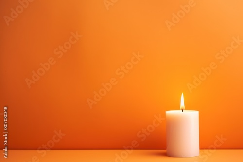 Orange background with white thin wax candle with a small lit flame for funeral grief death dead sad emotion with copy space texture for display 