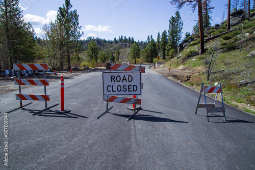 Barricades and signage mark a road closure in the Plumas National Forest due to post Dixie Fire repairs underway. photo