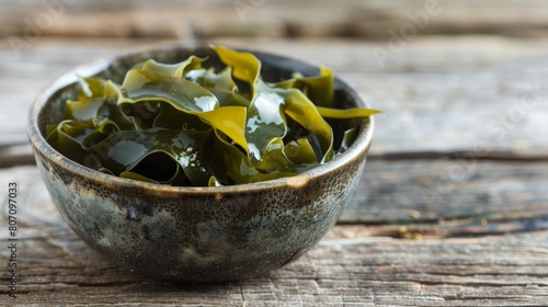 Laminaria seaweed in a bowl on wood background photo