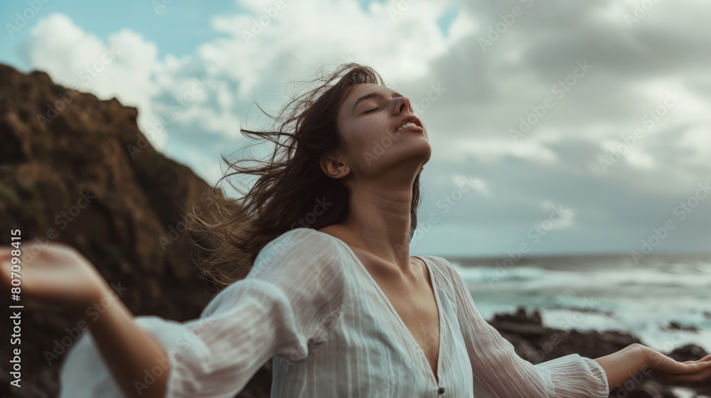 Woman in white dress open arms eyes closed enjoy sea breeze seaside rocky beach long hair Caucasian female Woman in white dress open arms eyes closed enjoy sea breeze seaside rocky beach long hair Caucasian female