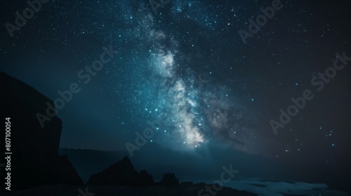 Starry night galaxy night sky full of stars above rocky beach ocean seaside mountain range photo