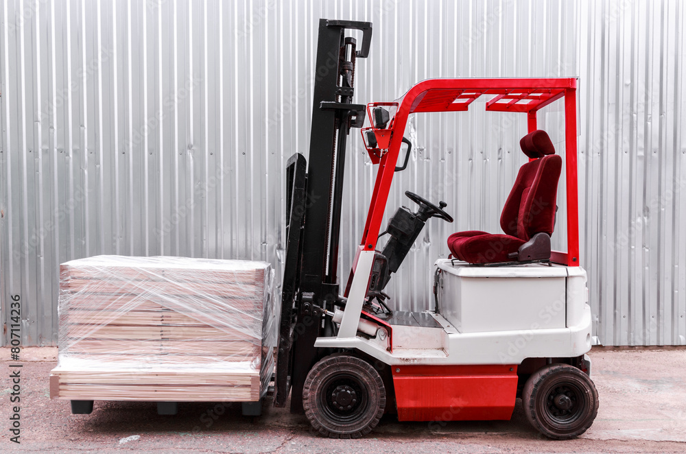 Red and White Forklift by a Pallet