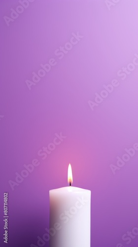 Purple background with white thin wax candle with a small lit flame for funeral grief death dead sad emotion with copy space texture for display 