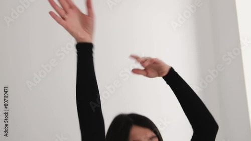 A young happy dark-haired woman is dancing in a photo studio.Hands in close-up.