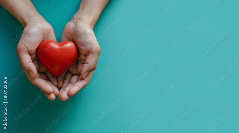 A person holding a red heart against a blue heart-shaped background A person holding a red heart against a blue heart-shaped background