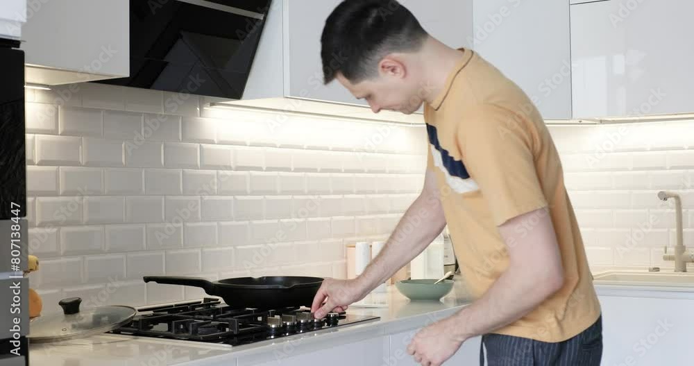 Caucasian man preparing omelet for breakfast and dancing in modern interior kitchen Caucasian man preparing omelet for breakfast and dancing in modern interior kitchen
