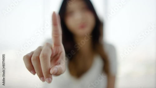 Portrait of young asian woman shaking finger in negation, person saying no with hand.