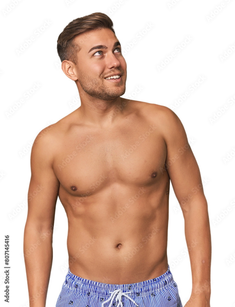 Shirtless young man in swimsuit against a studio backdrop, embodying summer vibes Shirtless young man in swimsuit against a studio backdrop, embodying summer vibes