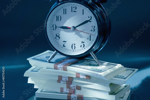 Time is money. Business, investment, financial assets and liabilities, earnings, passive income concept. Close up clock with money. Horizontal image.