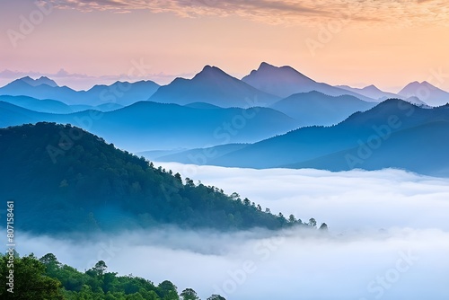A mountain range is covered in mist, with a blue sky above. © feroooz arts