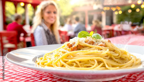 Spaghetti Cabonara, im Hintergrund ein Restaurant mit Gästen 