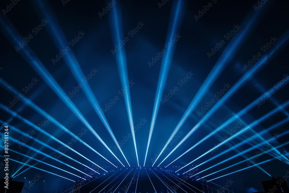 Abstract view of concert lighting, where blue beams glow against a dark sky, creating an illusion of an empty, electrifying air space