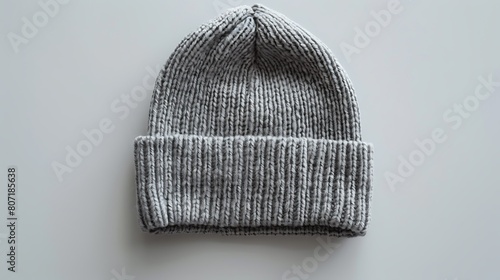 A gray knit beanie mockup folded neatly on a white backdrop  ideal for presenting seasonal fashion trends.