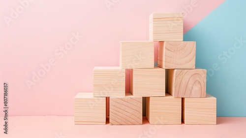 wooden cubes meticulously arranged in the shape of a pyramid against a light background  offering ample copy space for conceptual designs or messages