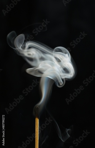 Smoking match with swirling white smoke