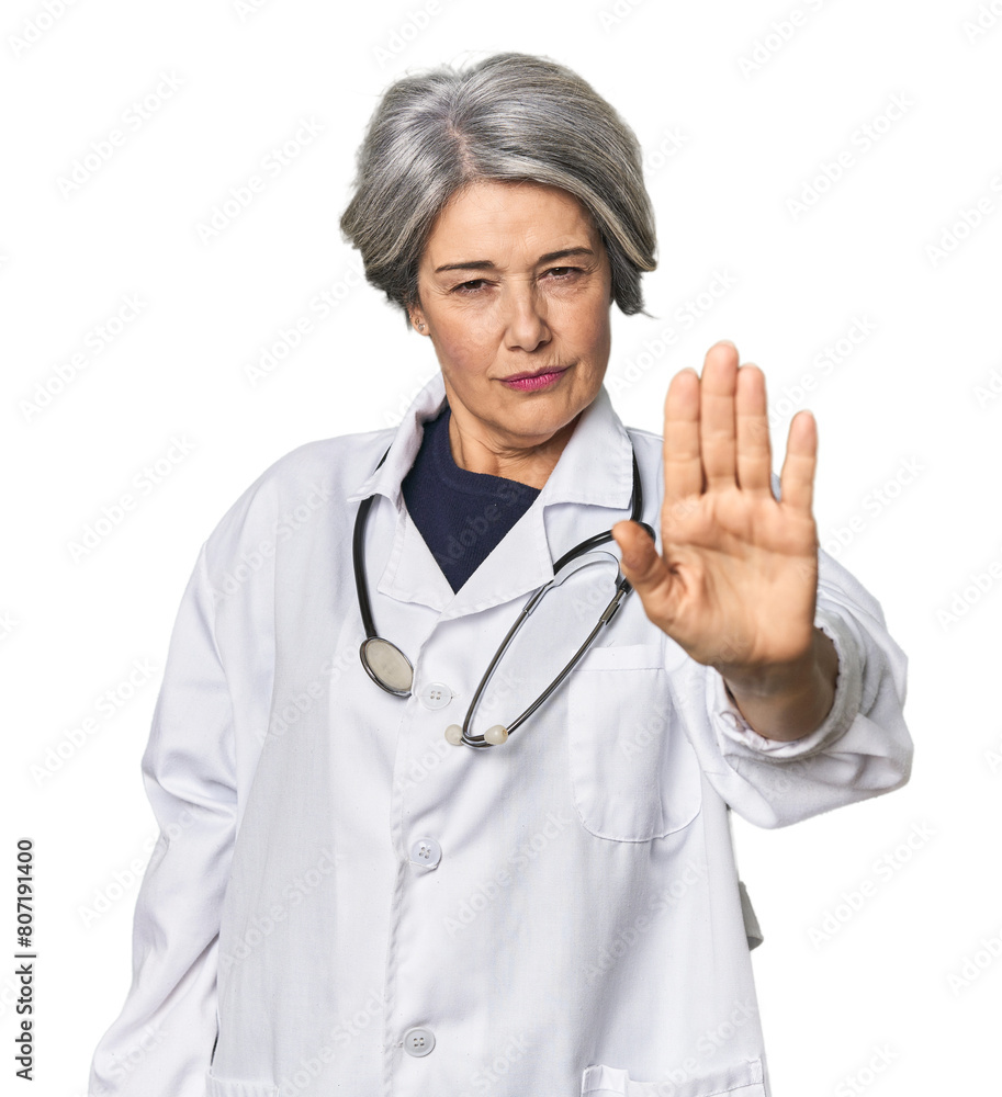 Caucasian mid-age female doctor with stethoscope standing with outstretched hand showing stop sign, preventing you. Caucasian mid-age female doctor with stethoscope standing with outstretched hand showing stop sign, preventing you.