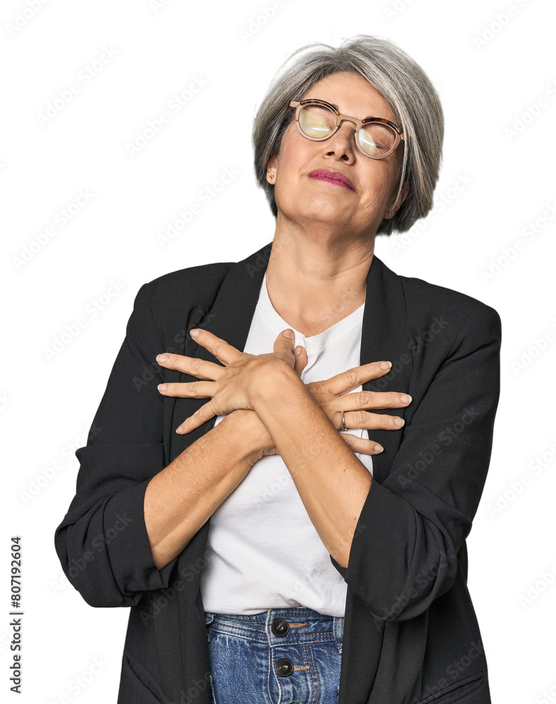 Caucasian mid-age female in business suit laughing keeping hands on heart, concept of happiness. Caucasian mid-age female in business suit laughing keeping hands on heart, concept of happiness.
