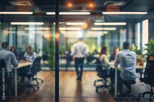 Blurred view of office team working through glass partition