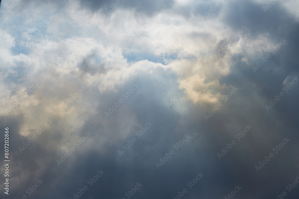 Sky with clouds through which heavenly light pours, sunlight passes through the clouds, light after the storm Sky with clouds through which heavenly light pours, sunlight passes through the clouds, light after the storm