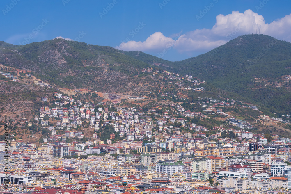 Top high angle view on little tiny houses with orange tiled roofs and green trees, mountains on bright summer sun. Top high angle view on little tiny houses with orange tiled roofs and green trees, mountains on bright summer sun.