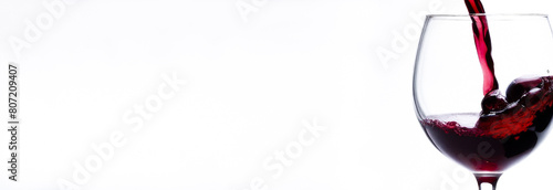 A banner of red wine pouring into a glass on a white background. free space for text © Екатерина Абатурова