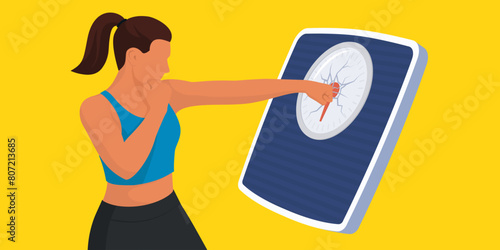 Fit woman breaking a weighing scale