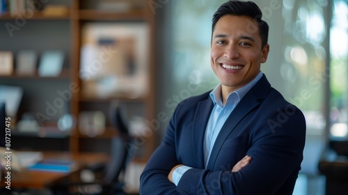 Smiling elegant confident young professional Latino hispanic business man , male proud leader, smart Latin businessman lawyer or company manager executive looking at camera standing in office