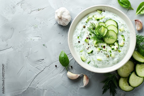 Greek tzatziki in white bowl on blue background top view