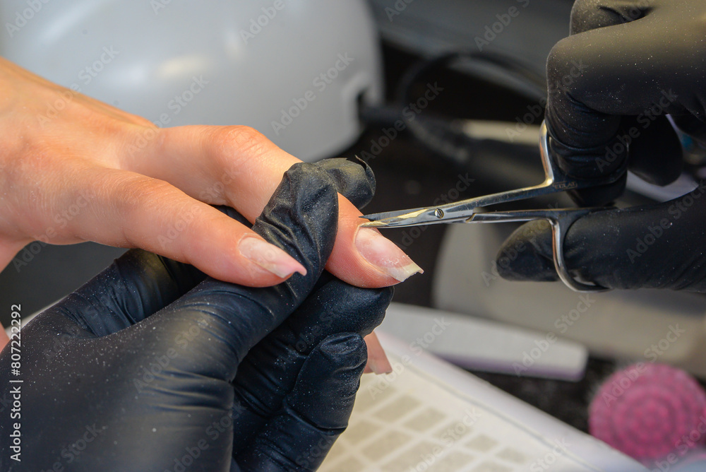 Close-up manicure process, female hands painting nails