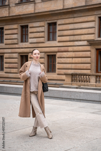 Young beautiful woman wearing coat walking in the city centre of Prague, Europe © dtatiana