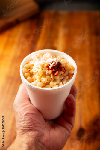 Esquites. Corn kernels cooked and served with mayo, sour cream, lemon and chili powder, very popular street food in Mexico, also known as Elote en Vaso. The recipe varies depending on the region.