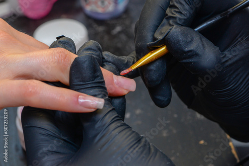 Close-up manicure process  female hands painting nails